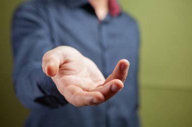 Adam yeşil arka planda açık avuç gösteriyor