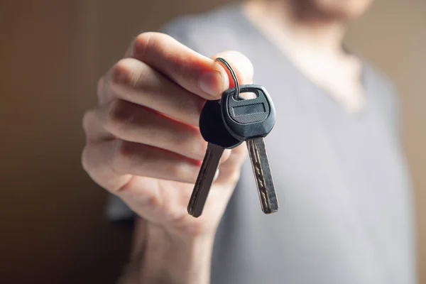 Man Holding House Keys Brown Background — Stock Photo, Image