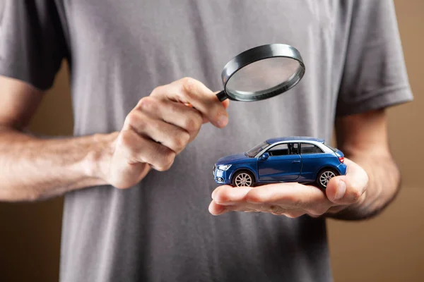 男は虫眼鏡で車を見ている 車検索の概念 — ストック写真