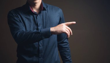 Adam kahverengi arkaplanı işaret ediyor