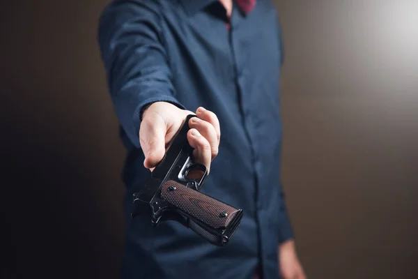Чоловік Дає Пістолет Коричневому Тлі — стокове фото