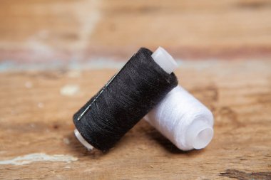 İplikler masanın üzerinde. Tahta bir masanın üzerinde siyah beyaz iplikler