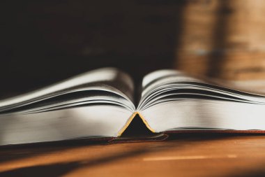 Tahta bir masanın üzerinde açık bir kitap