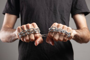 Yumruklarında zincir tutan bir adam.