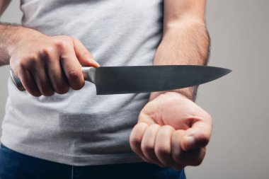 Bir adam mutfak bıçağıyla damarlarını kesmek ister.