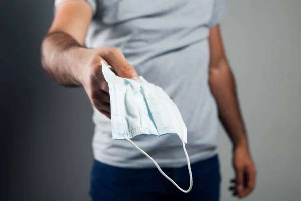 Man Som Håller Medicinsk Mask Handen Grå Bakgrund — Stockfoto