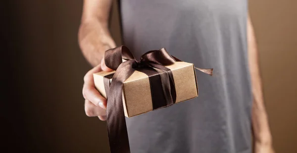 Man Holding Gift Box Brown Background — Stock Photo, Image