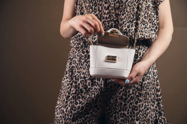 Elbiseli genç kadın çantasını açıyor.