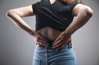Genç bir kadının sırtı ağrıyor.