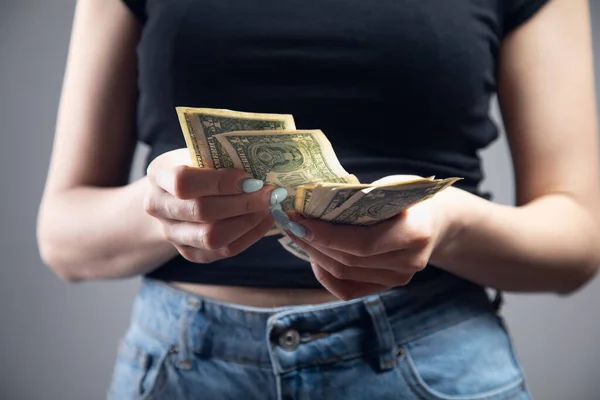 woman is counting money on gray background