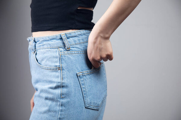 Молодая девушка вытаскивает деньги из заднего кармана