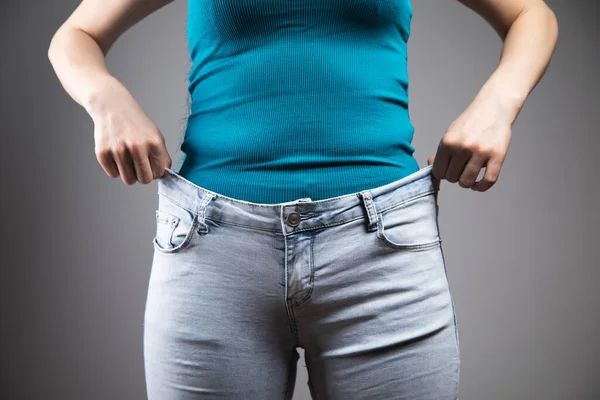 Genç Kız Gri Arka Planda Kot Pantolon Giyiyor — Stok fotoğraf