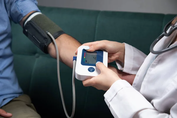 Medic Verifică Tensiunea Arterială Unui Bărbat Dispozitiv Electronic Canapea — Fotografie, imagine de stoc