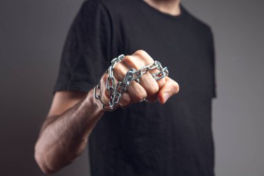Yumruğunda zincir tutan bir adam.