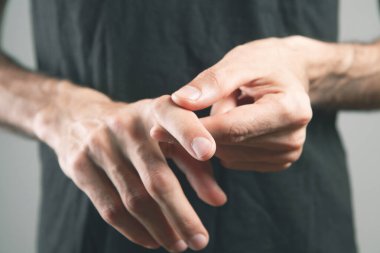 Adamın arka planda yaralı bir parmağı var.