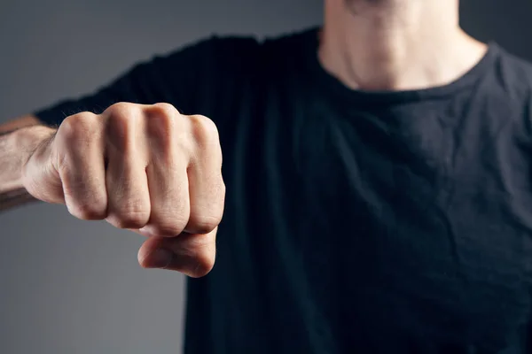 Adam gri arka planda yumruğunu gösteriyor