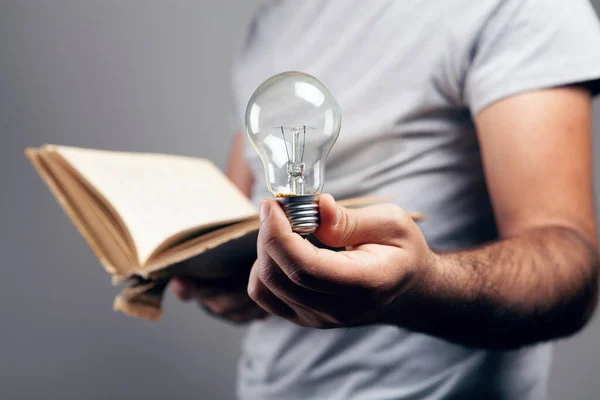 man holding an open book and a light bulb. concept idea from a book