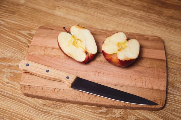 Tahtada dilimlenmiş elma ve bıçak var.