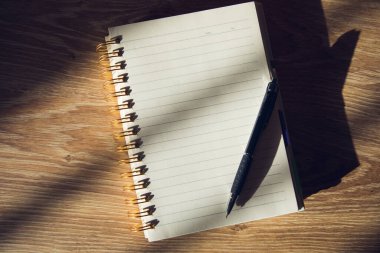 Kalem ve defter masanın üzerinde.