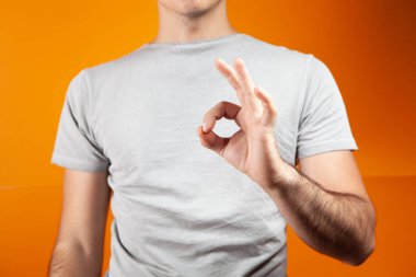 Adam turuncu arka planda iyi görünüyor.