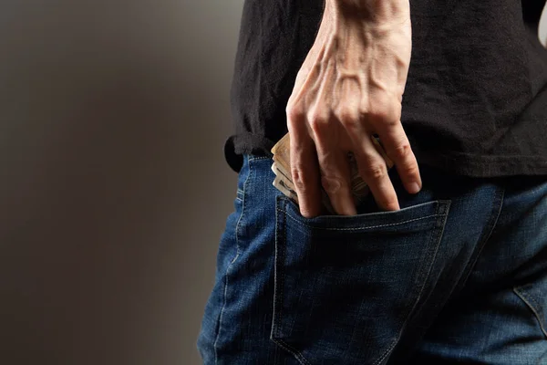 Hombre Pone Dinero Bolsillo Trasero Sobre Fondo Gris — Foto de Stock