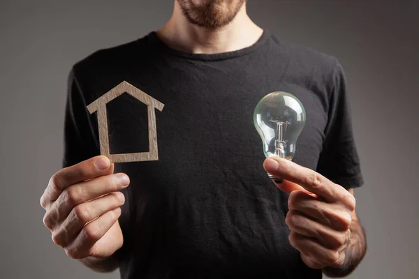 holding a house and a light bulb