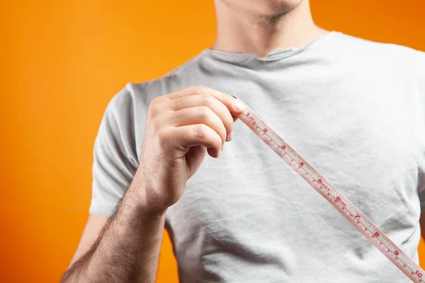 Man measuring his waist with a tape measure 2246454 Stock Photo at Vecteezy