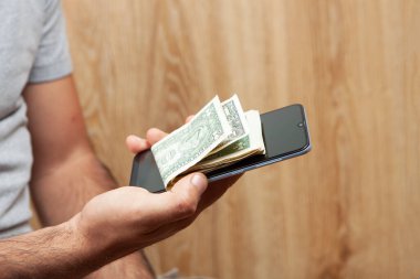 Telefon ve para elinde.