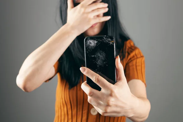 Mujer Mostrando Pantalla Del Teléfono Roto Sobre Fondo Gris —  Fotos de Stock