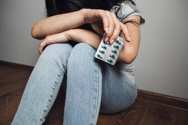 Woman Sitting Floor Holding Pills Stock Photo