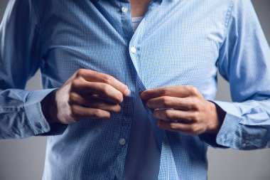 Bir erkek gömlek giyer.