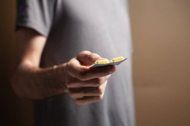 Elinde hap tutan bir adam.