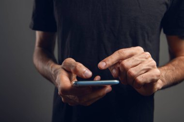 Adam telefon ekranına bastırıyor.