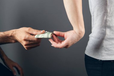 Arkadan gizlice para veriyor.