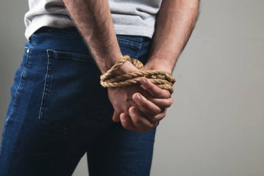 Adamın elleri bir iple bağlanmış.