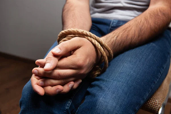 Adamın elleri bir iple bağlanmış.