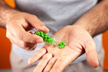 Bir adam eline hap verir.