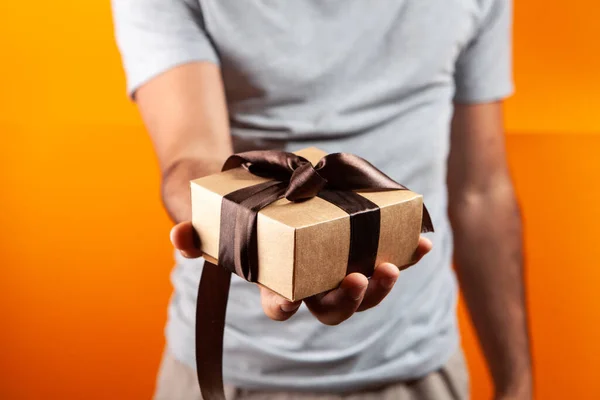 Man Holding Gift Box His Hand Orange Background — Stock Photo, Image