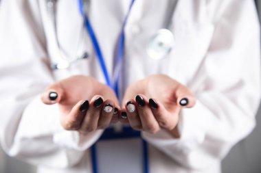 Doktor avuçlarını bir tezgah gibi boş tutuyor.