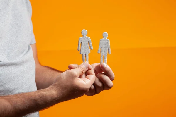 Hombre Sosteniendo Figuras Personas Sus Manos Sobre Fondo Naranja — Foto de Stock