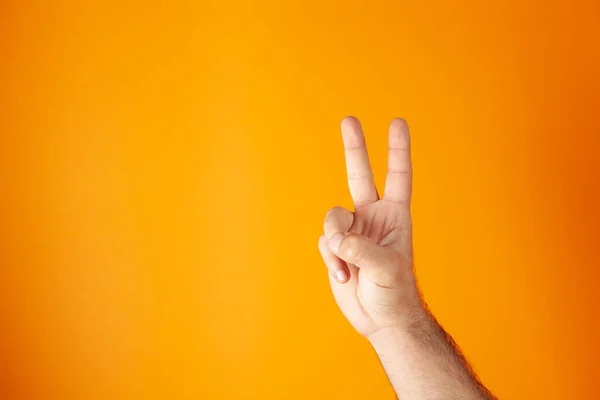 Hand Shows Peace Sign Orange Background — Stock Photo, Image