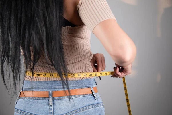 用带子测量腹部的年轻女人 — 图库照片