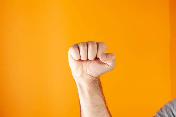 Hand Toont Vuist Oranje Achtergrond — Stockfoto