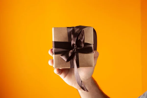 Hand Holds Gift Box Orange Background — Stock Photo, Image