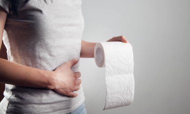 Kadın tuvalet kağıdı ve mide ağrısıyla ayakta duruyor.