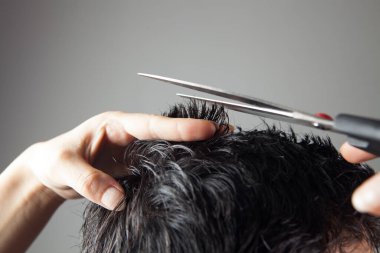 berber, saç kesen adamları makasla keser.