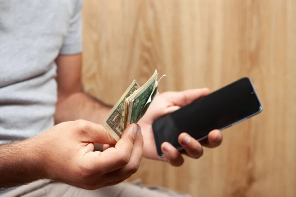 hand holds phone and money