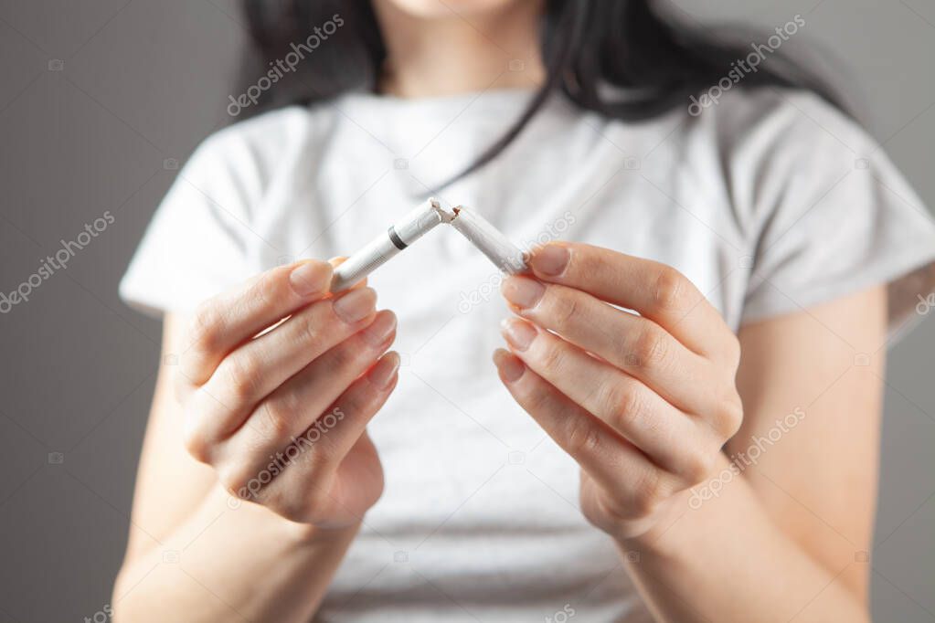 young girl breaks a cigarette