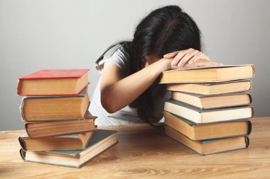 Kız kitapların yanındaki masada uyuyor.