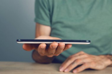 Elinde tablet tutan bir adam.